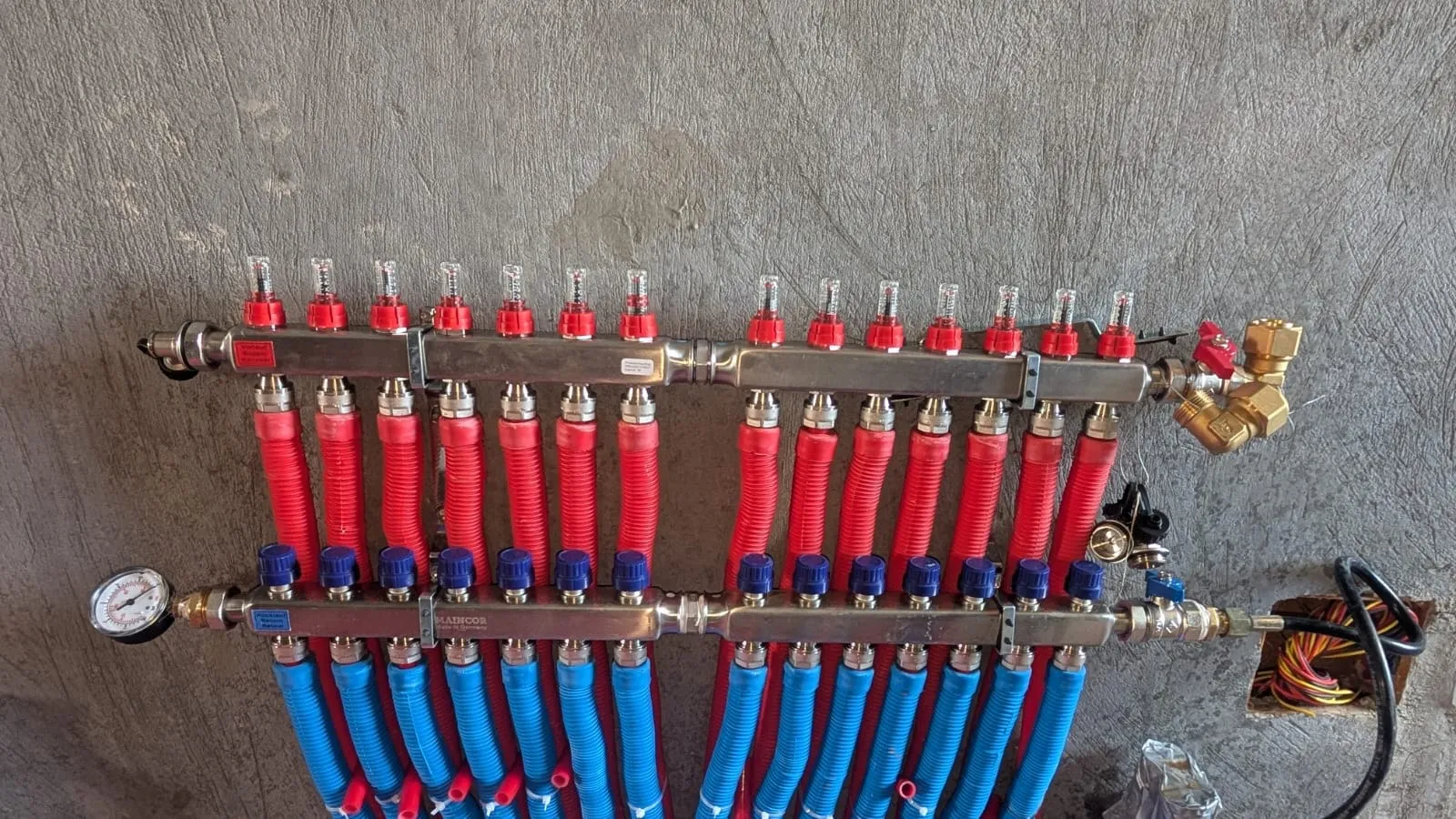 Underfloor heating distribution manifold on a project wall